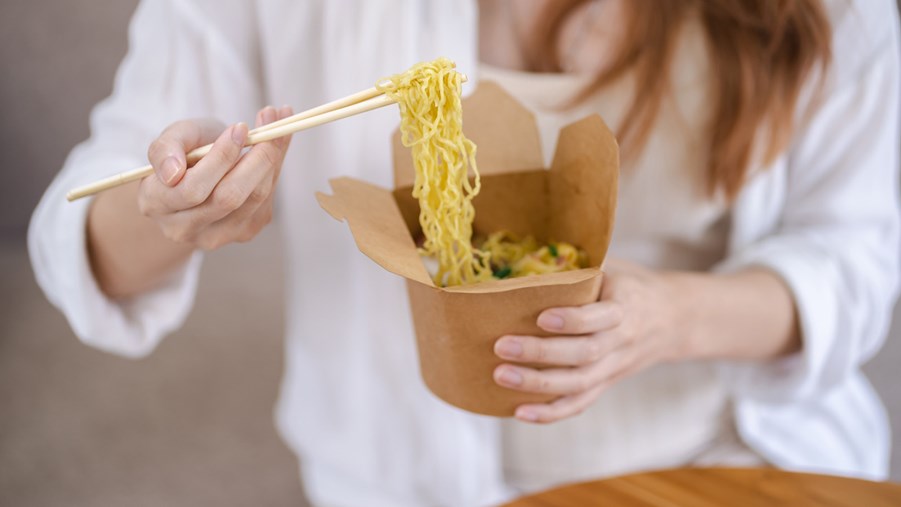 kvinna äter ur pappersförpackning