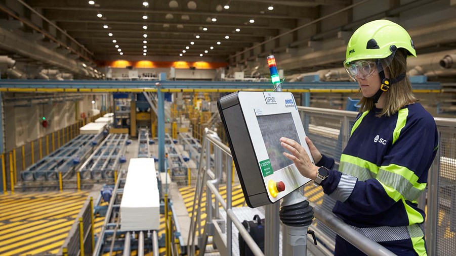 industriarbetare står vid datorskärm